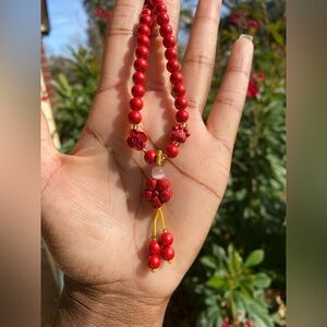 Red beaded necklace with flower focal bead
